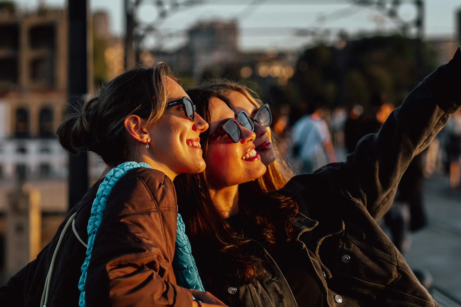 Three friends in sunglasses smiling in the evening sun